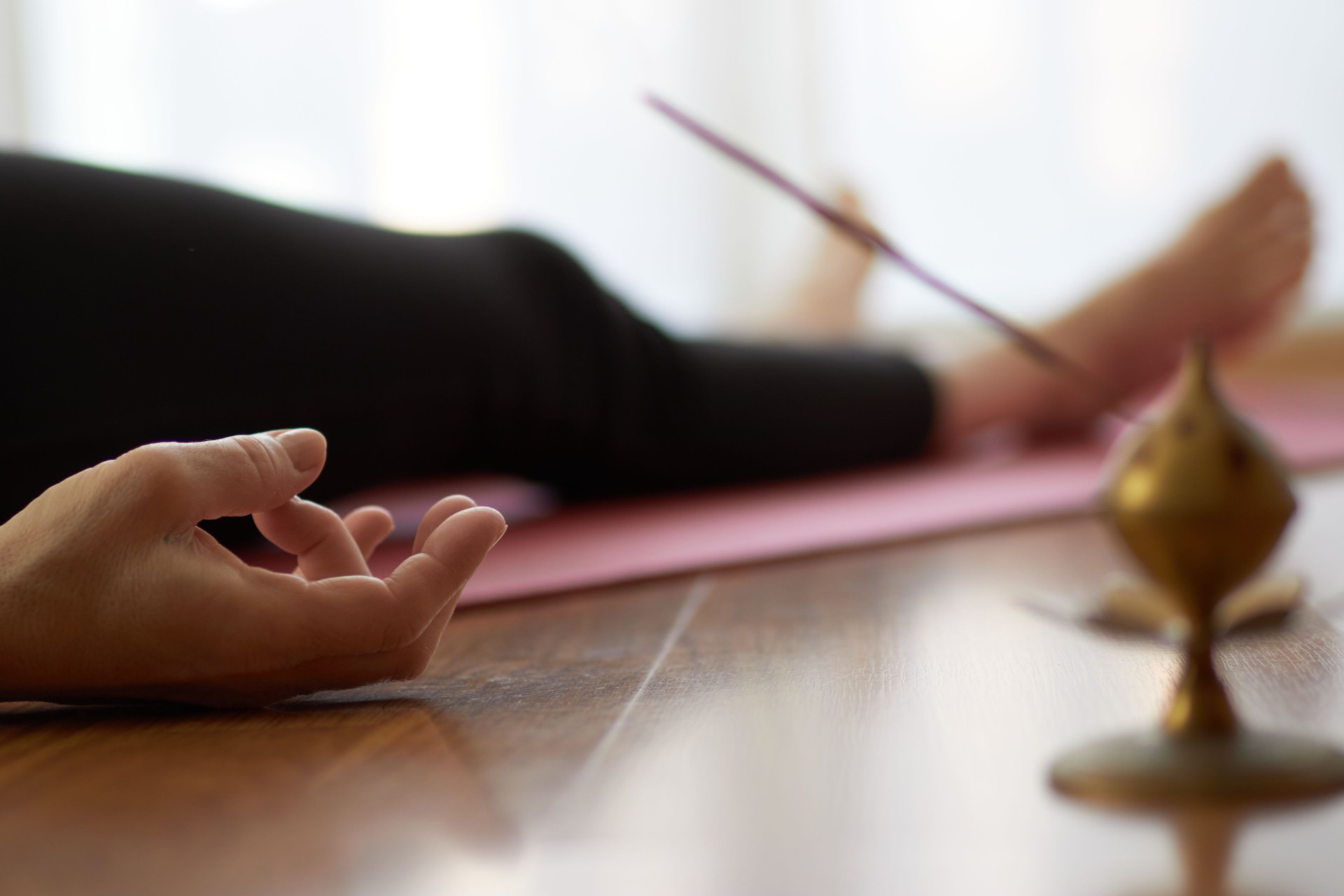 woman practicing yoga, lying in yoga nidra pose, exercise in Shavasana, exercises, work, rest after practice, female hand.