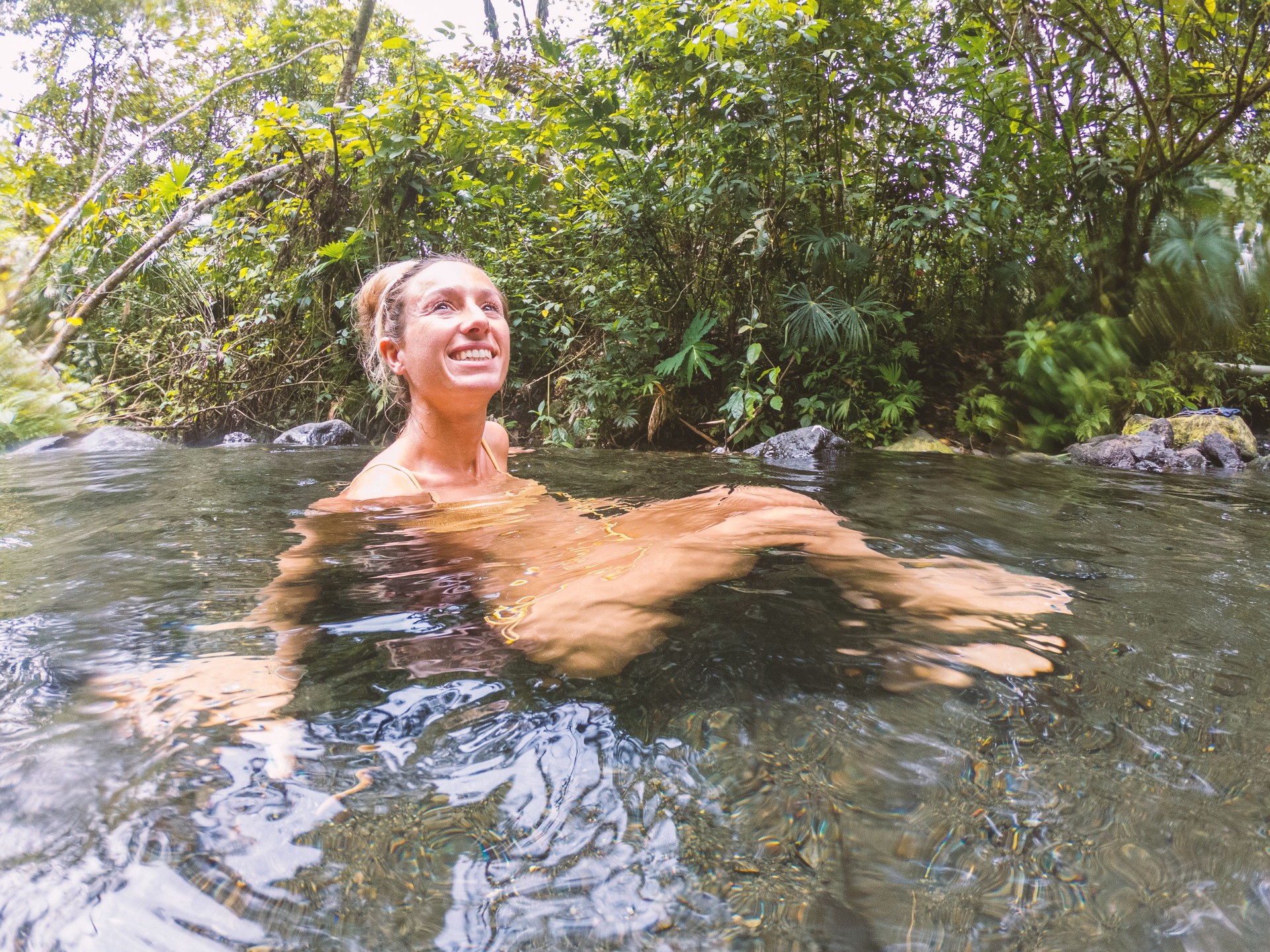 Young woman bathing in hot river in Costa Rica
